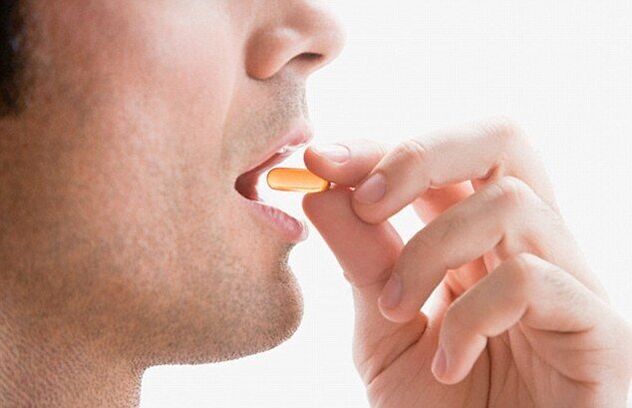Un home toma un complexo vitamínico para manter a potencia